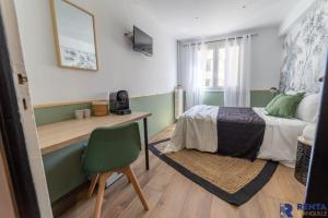 尼斯Room Riviera 3 Aéroport Wifi Climatisation的一间卧室配有一张床、一张桌子和一把椅子