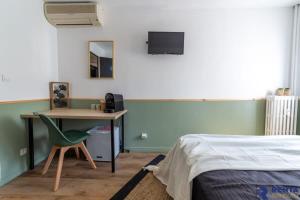 尼斯Room Riviera 3 Aéroport Wifi Climatisation的一间卧室配有一张桌子和一张床,一张桌子和椅子