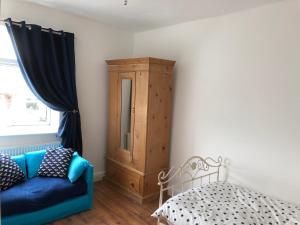 RenishawHilltop Cottage的一间设有蓝色沙发和木制橱柜的客房