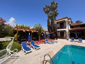 凯麦尔Palma Rosa Hotel的一个带躺椅的游泳池以及一座房子