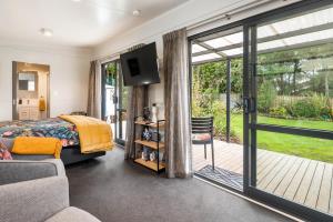 图朗伊Birdsong - Turangi Holiday Unit的一间卧室设有一张床和一个滑动玻璃门