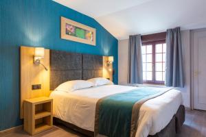 埃斯卡勒Hôtel L'Escale - Piscine & SPA的一间卧室设有一张蓝色墙壁的大床