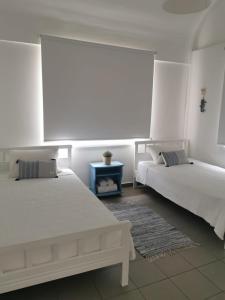 利马索尔Nostalgia apts的一间卧室配有两张床和一张蓝色的桌子