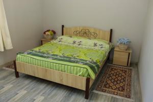 苏呼米Casa-Colina 2 вид на горы и море的一间卧室配有一张带绿色棉被的床