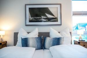 卡珀尔恩Koje No1的一张带枕头的白色床和墙上的照片