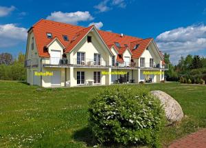 高尔维茨Gollwitzer Park Sturmvogel的绿色田野上一座红色屋顶的房子