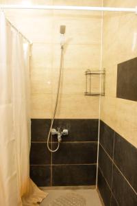 苏呼米Casa-Colina 2 вид на горы и море的一间带淋浴的浴室,配有黑色瓷砖墙