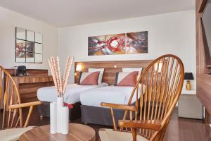 沙西约Hotel Gatsby by HappyCulture的酒店客房带两张床和一张桌子以及椅子。
