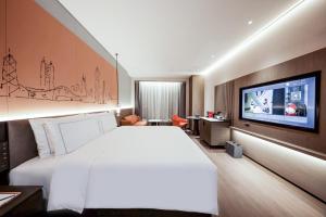 深圳深圳罗湖盛业逸扉酒店的一间酒店客房,配有一张大床和一台平面电视