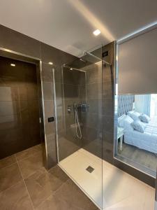 利多迪耶索罗切利尼公园酒店的一间带玻璃淋浴间和床的浴室