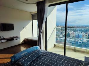 Phu YenHoa vàng trên cỏ xanh的一间卧室设有蓝色的床和大窗户