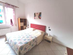 斯培西亚Casa SOFIA La Spezia的一间卧室配有一张红色床头板的床