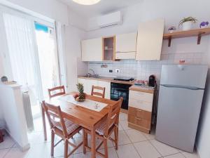斯培西亚Casa SOFIA La Spezia的厨房配有木桌和白色冰箱。