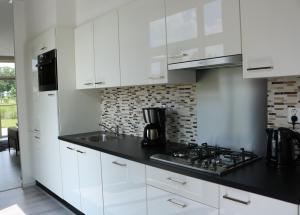 SusterenChalet Aleblie的白色的厨房设有水槽和炉灶。