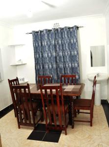 KakamegaPacific Homes @milimani court, kakamega的一间带木桌和椅子的用餐室