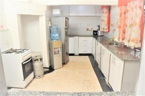 KakamegaPacific Homes @milimani court, kakamega的厨房配有白色家电,铺有瓷砖地板。