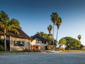 楚梅布La Rochelle Lodge Namibia Tsumeb的棕榈树街道上的房屋