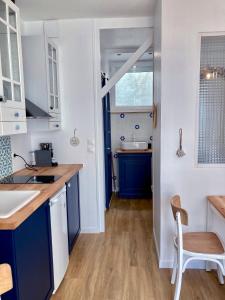 基伯龙Studio Tehani的厨房配有蓝色橱柜和水槽