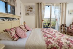 SemadarSuite Kolibri in Galilee的一间卧室配有带粉红色枕头的床和阳台