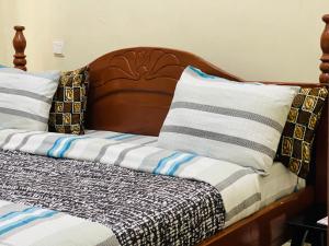 鲁亨盖里Virunga Homes的一张带木制床头板和枕头的床