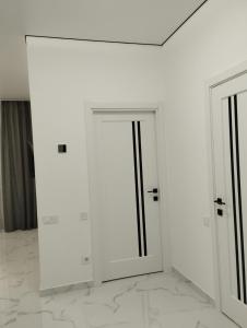 捷尔诺波尔Елітна квартира-студія .的一间白色的房间,设有两扇门和一堵墙