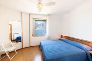 托尔博莱Residence Casa al Sole Apartments的一间卧室设有蓝色的床和窗户。