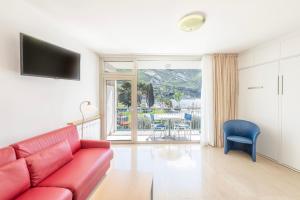 托尔博莱Residence Casa al Sole Apartments的客厅配有红色沙发和蓝色椅子