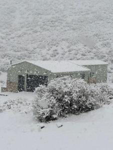 洛斯莫莱斯Piri Home Casa de Montaña的田间中积雪覆盖的房子