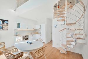 韦内雷港L'incanto di Venere的白色的客房配有桌椅和螺旋楼梯