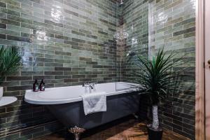 兰迪德诺Russell Court by Orenda-Luxe的带浴缸和植物的浴室