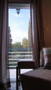波多河丽Angelique Όμορφο διαμέρισμα στο Porto Heli的卧室设有窗户,享有树木美景