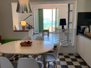 芒通Villa Capodanna, au coeur de la vieille ville, rooftop avec magnifique vue sur la mer的厨房以及带桌椅的用餐室。