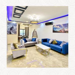 瓦加杜古RESIDENCE KARMA的客厅配有蓝色的沙发和桌子