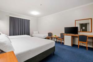 珀斯Metro Hotel Perth City的一间酒店客房,设有两张床和电视