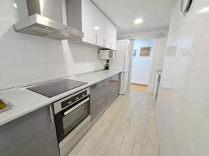 瓦伦西亚Céntrico apartamento en Valencia próximo parada de metro Ángel Guimerà的厨房配有水槽和炉灶 顶部烤箱