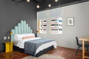开普敦BlackBrick Cape Town Foreshore的一间卧室配有一张蓝色床头板的床