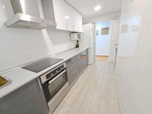 瓦伦西亚Céntrico apartamento en Valencia próximo parada de metro Ángel Guimerà的铺有木地板的厨房配有白色家电