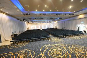埃拉特莱昂纳多俱乐部埃拉特 - 全包酒店的一间大房间,配有椅子和舞台