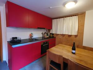 雷金根Gadä 2的厨房配有红色橱柜和木桌