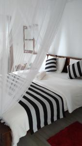 埃拉Holly House Homestay的白色的床、黑白色枕头和窗户