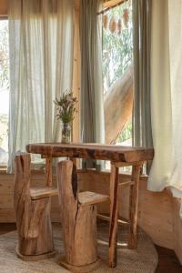 阿尔热祖尔Soul Farm Algarve - Glamping & Farm Houses的窗户客房内的一张木桌和椅子