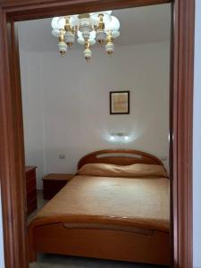 贡内萨Domus Shardana的一间卧室配有一张床和一个吊灯