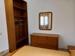 贡内萨Domus Shardana的一间卧室配有一张床、梳妆台和镜子