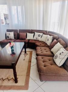 塔那那利佛B&B/chambres d'hôtes的客厅配有棕色沙发和玻璃桌