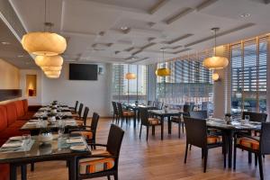 迪拜La Suite Dubai Hotel & Apartments的用餐室设有桌椅和窗户。