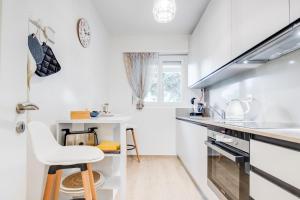 洛迦诺RELAX Camelia Apartment的白色的厨房配有凳子和水槽