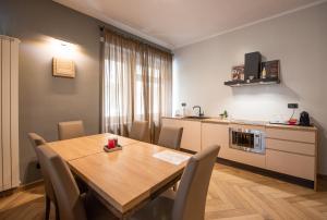 都灵Top Living Apartments - Casa Valentino的厨房以及带木桌和椅子的用餐室。