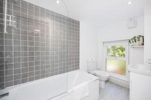 伦敦WelcomeStay Colliers Wood Two Bed Apartment - Home Away from Home的白色的浴室设有浴缸和卫生间。