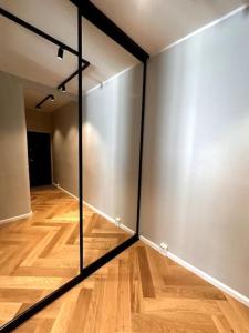 赫尔辛基Luxury City Center Suite的一间设有镜子的墙壁和木地板的客房