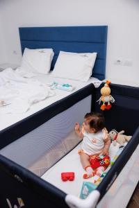 卡萨米尔CAPTAIN'S RESIDENCE的婴儿坐在床上,带玩具